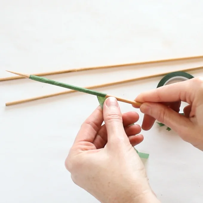 Covering the bamboo skewer with green floral tape