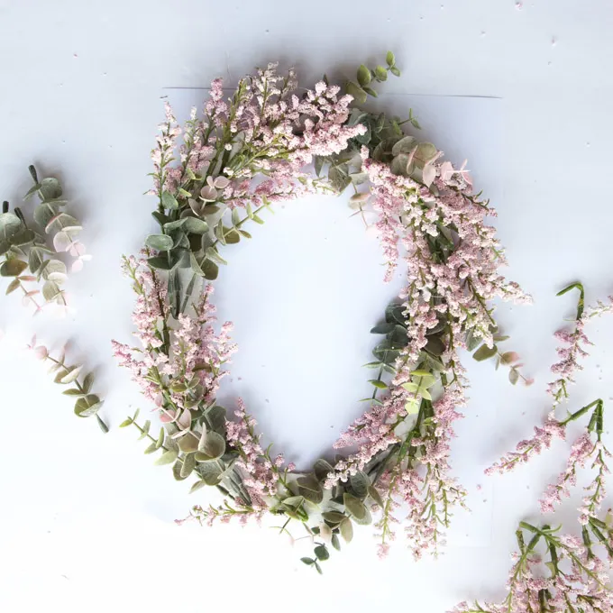 Close up of the flowers and eucalyptus arranged together into a letter O shape. 