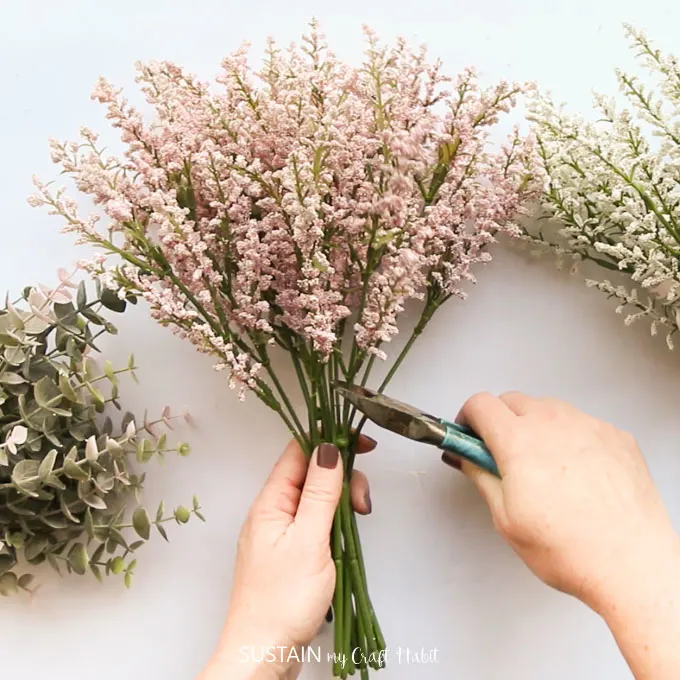 Using wire snippers to separate the pink and white floral bunch. 