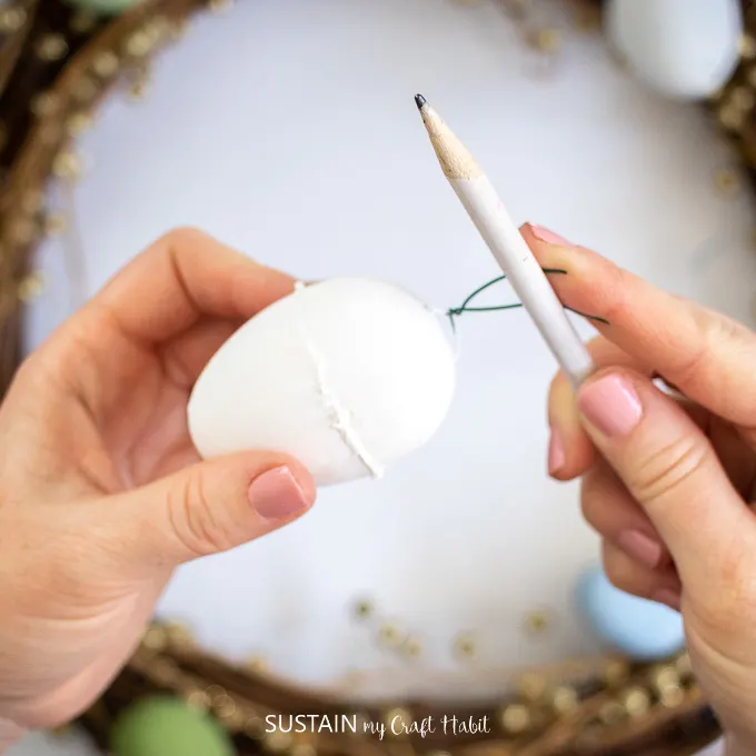 Attaching floral wire to the Easter egg.