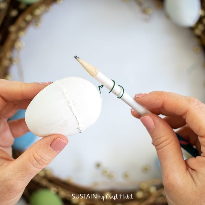 Using a pencil to bed the floral wire on the Easter egg.