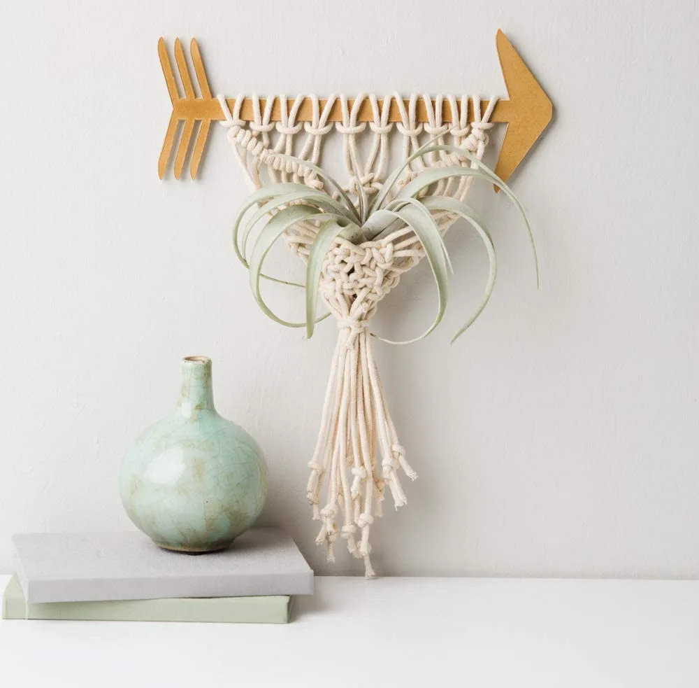 Adorable macrame plant hanger made with a wooden arrow foundation.