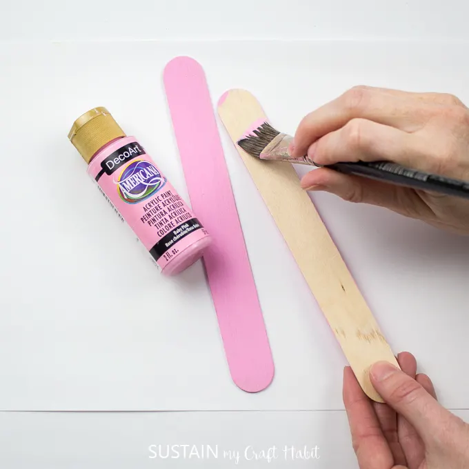 Painting a wooden popsicle stick in DecoArt baby pink color.