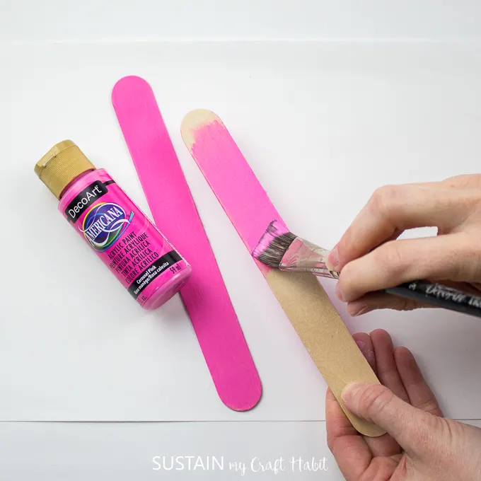 Painting a wooden popsicle stick in DecoArt carousal pink color.