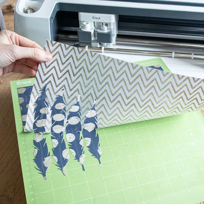 Removing the cut polka dot paper feathers from the Cricut machine.