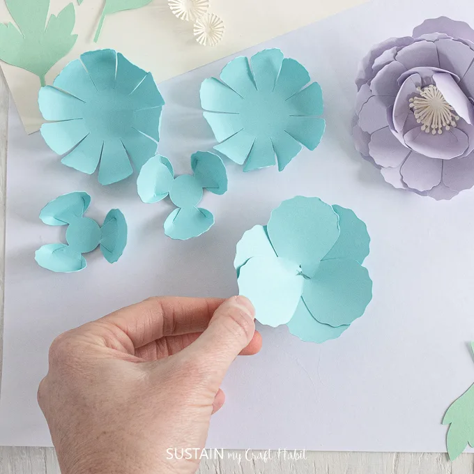 Gluing a blue petal to the top of another petal.
