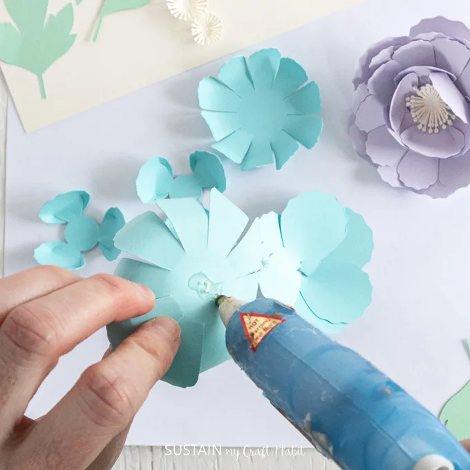 Adding hot glue to the bottom of the blue petal.