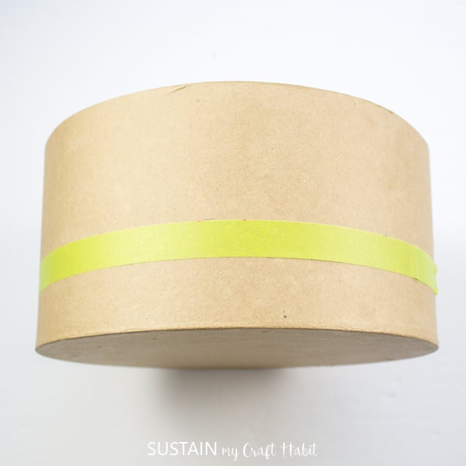 Placing painters tape around the circumference of the craft hat box.