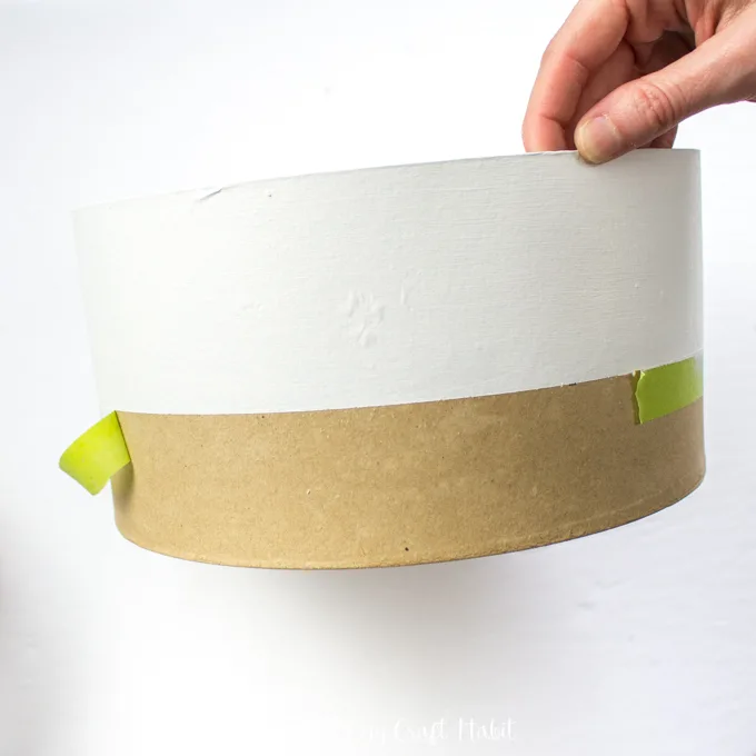 Removing painter's tape from a craft hat box.