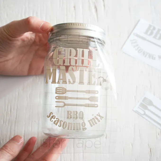 Pressing down the vinyl image onto the front of a mason jar.