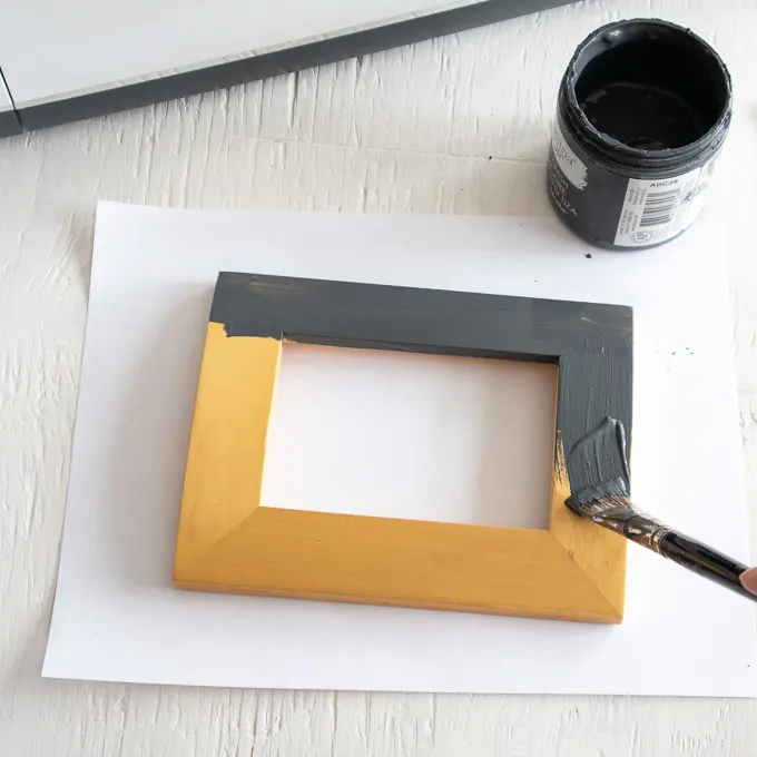 Painting a wood photo frame with charcoal colored paint.