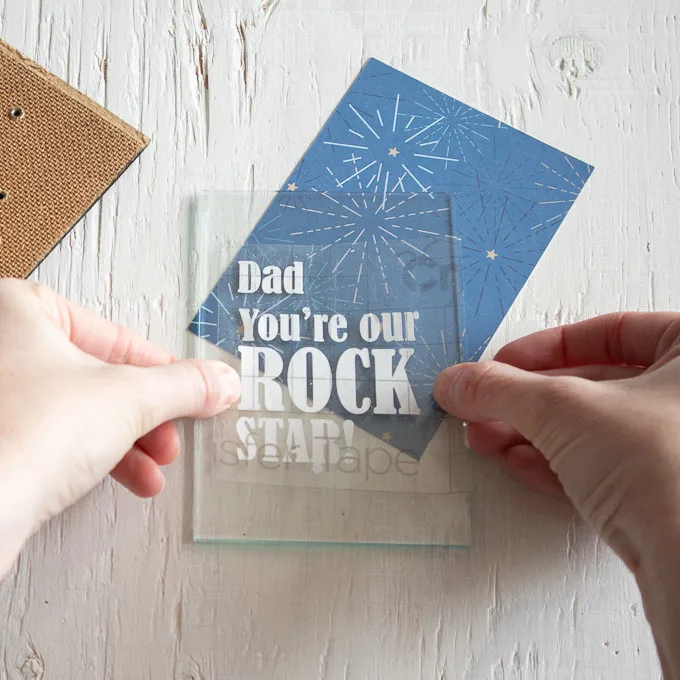 Adding the cut phrase onto the front glass of the picture frame.