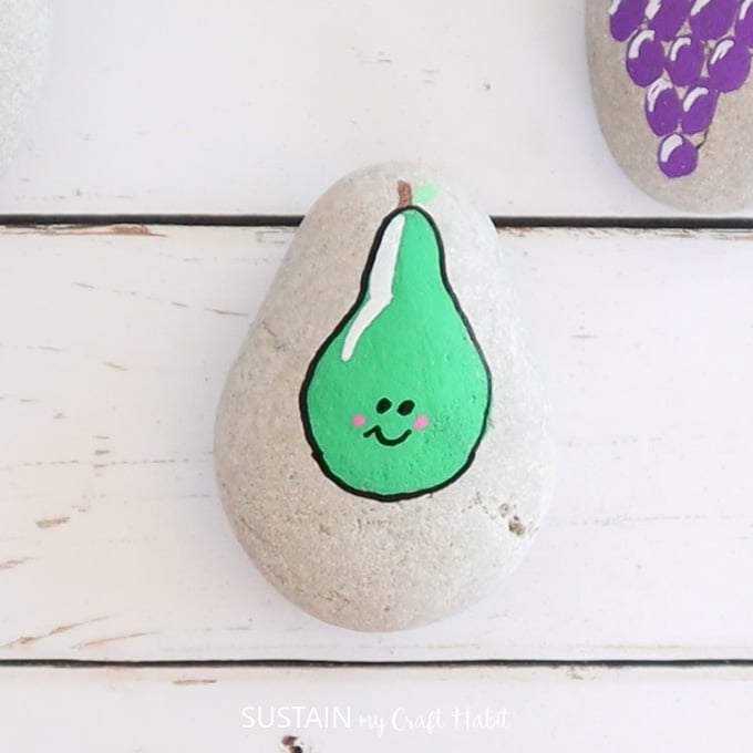 Outlining the pear shape and adding a smiley face.