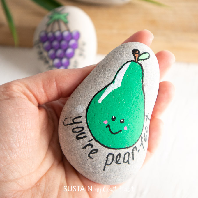 Adding "you're pear-fect" text to the painted rock.