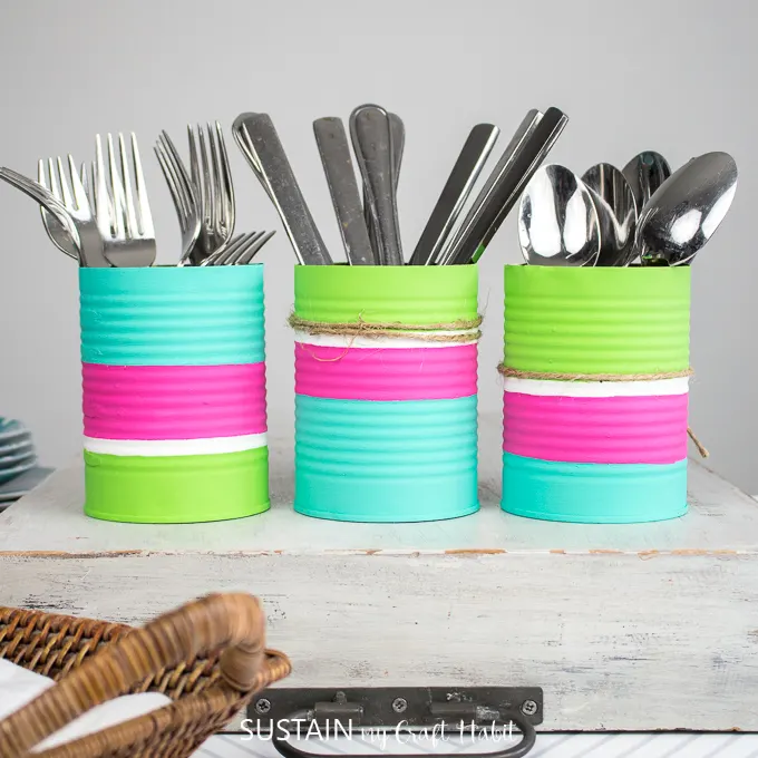 Finished utensil holders with twine wrapped around it and filled with forks, knives and spoons.