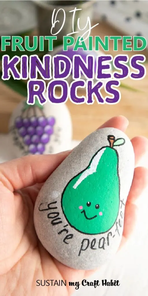 Close up of a rock painted with a pear and text overlay "DIY fruit painted kindness rocks."