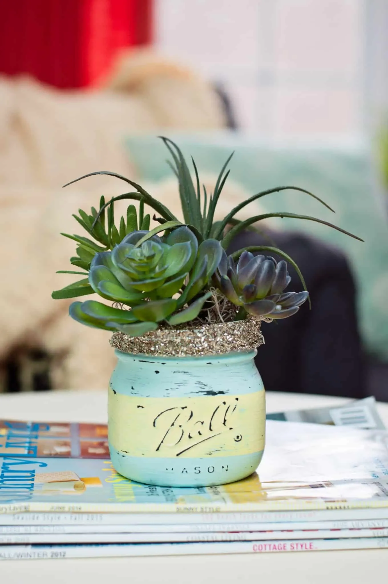 Painted mason jar with a succulent placed inside.