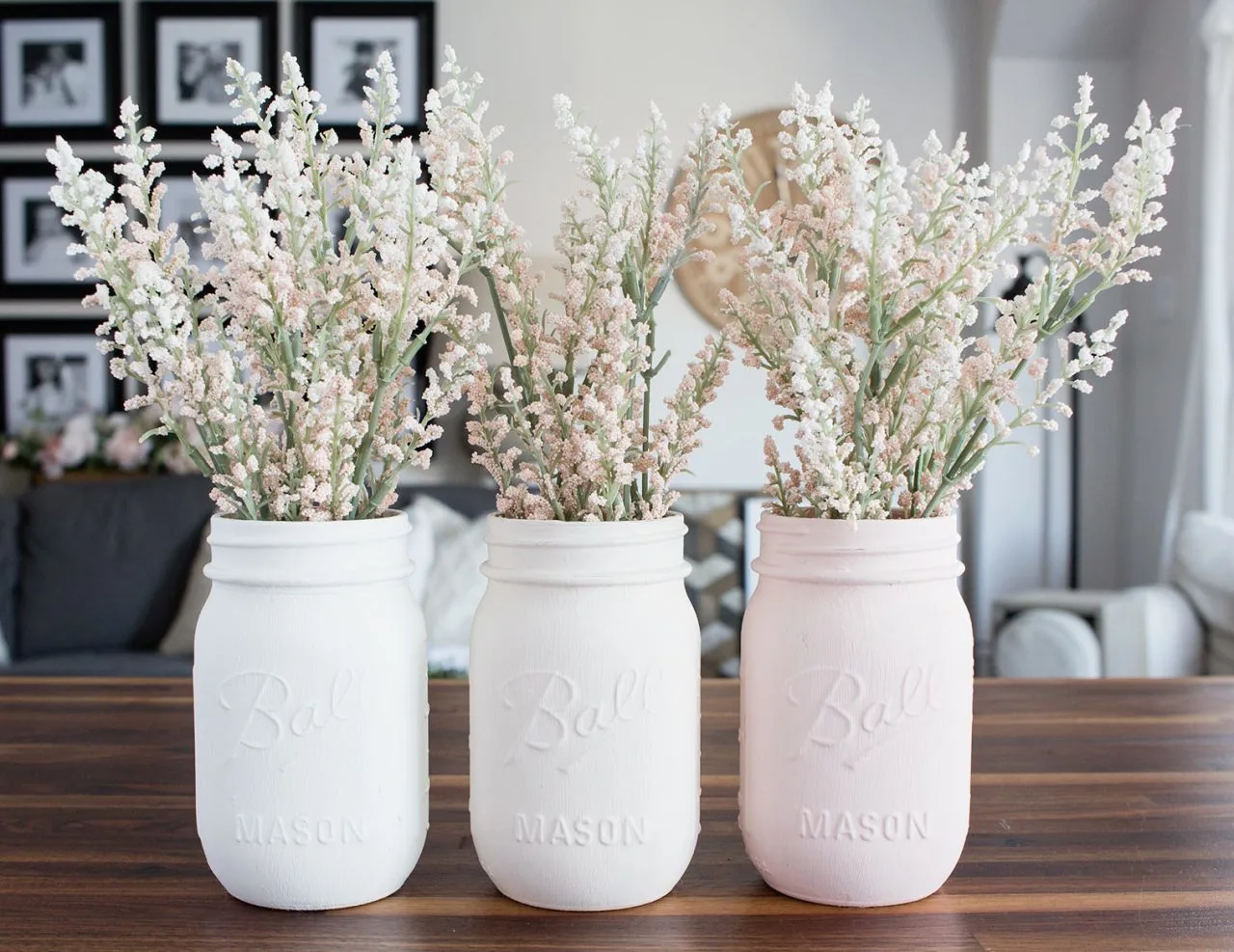 Mason jar vases painted white, cream and light pink with flowers.