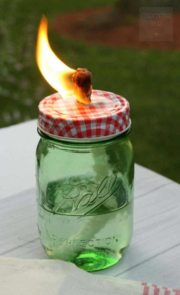Lit citronella candle in a mason jar.
