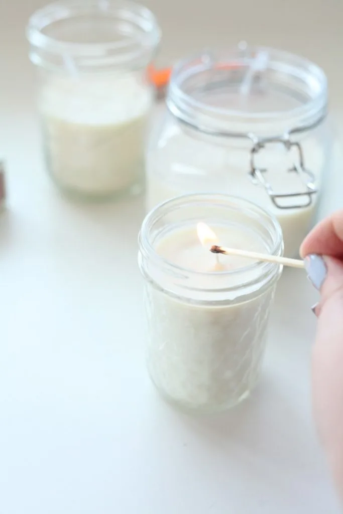 Lighting a mason jar candle with a match.