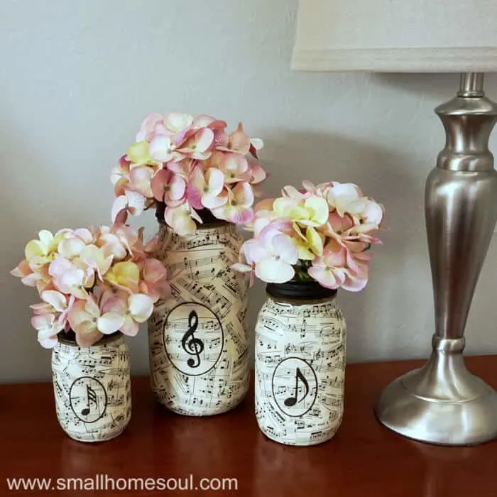Music sheet mason jar vases with flowers.