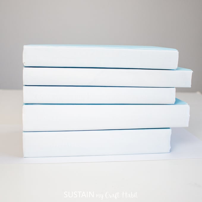 Stacking the painted hardcover books horizontally.