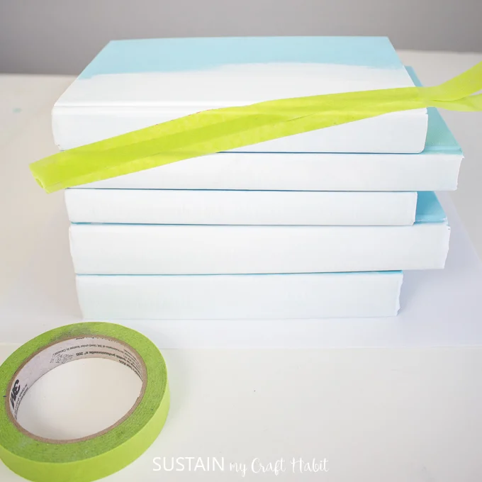 Adding green painter's tape to the book stacked at the top.