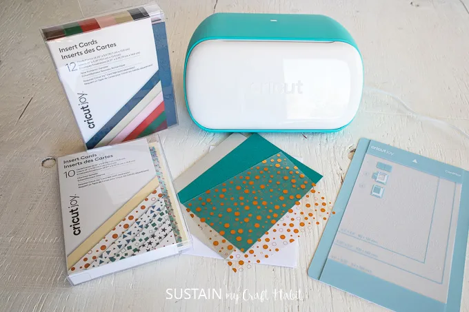 Materials needed to make a card including a Cricut joy machine, card mat, cards and insert cards.