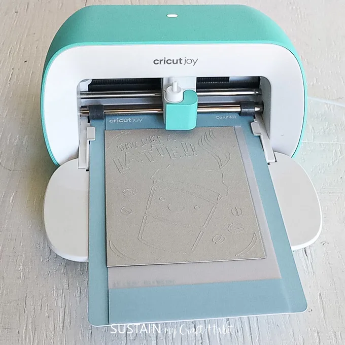 Cricut joy machine cutting out an image on the card stock.