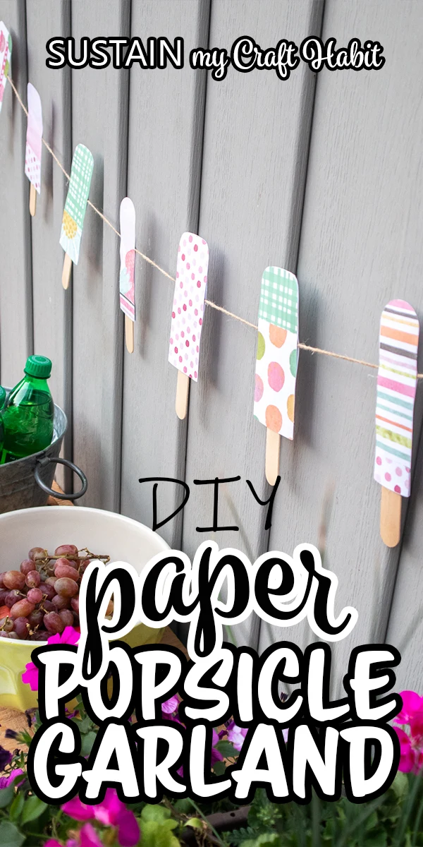 Colorful paper popsicle garland decor hung against a grey wall with text overlay "DIY paper popsicle garland."