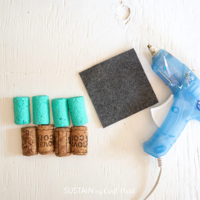 Gathering the blue painted wine corks along with a piece of felt fabric and a hot glue gun.