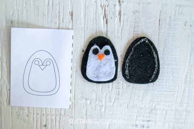 Gluing two of the black felt fabric pieces to make a penguin.