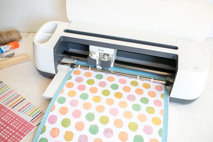 Loading polka dot paper into the Cricut machine.