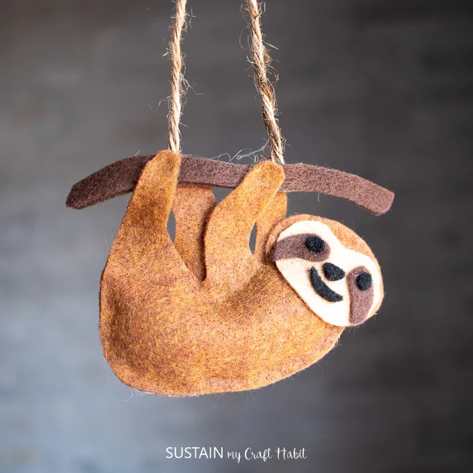 Finished craft with no-sew felt sloth hanging from a piece of twine. 