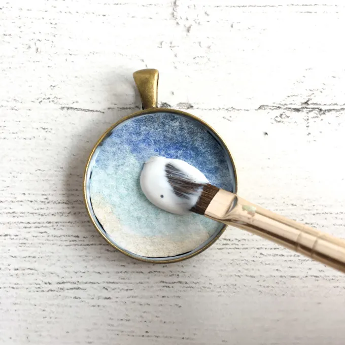 Adding the watercolor image and sealing it onto the bezel jewelry pendant.