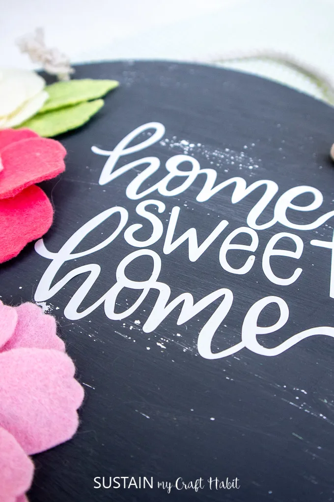 Close up of the home sweet home vinyl on the painted wood sign.