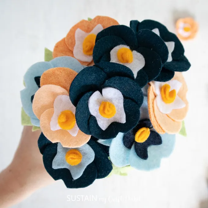 Felt pansies attached to a Styrofoam ball to look like a bouquet.