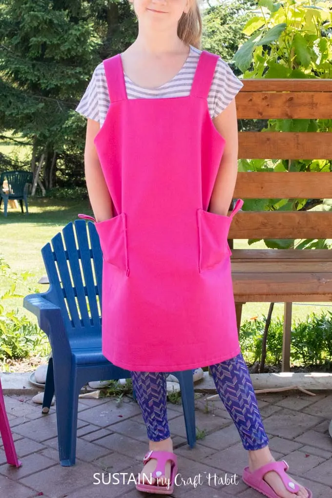A child wearing a pink kid's apron.