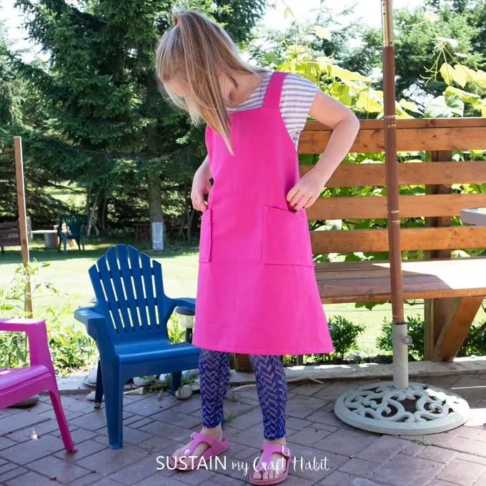 9 year old girl modelling versatile kids apron made with sewing pattern