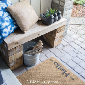 photo of a front porch with a painted welcome mat and seating area
