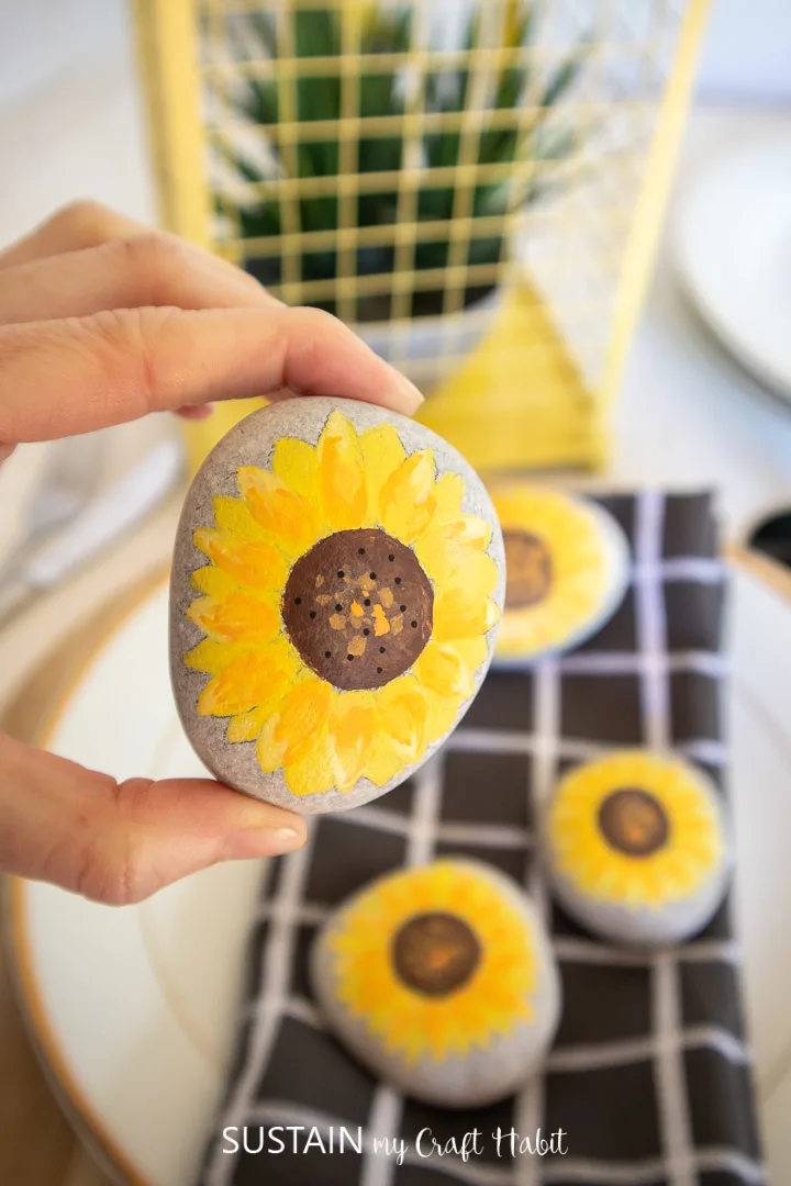 Close up image of a sunflower painted rock as an example of a sunflower craft.