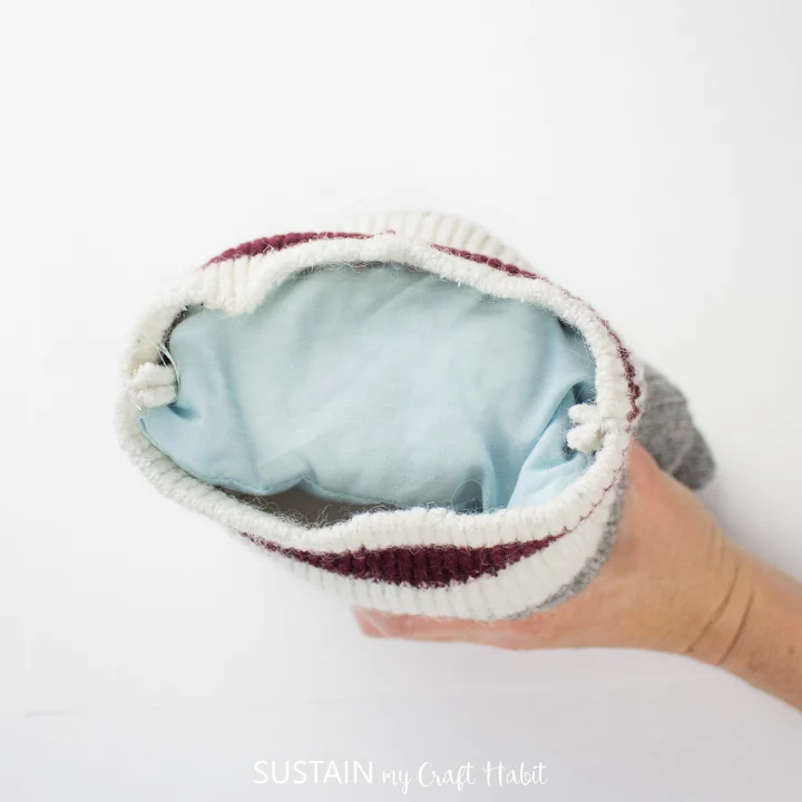 Adding the pouch filled with dried beans to the bottom of the socks.