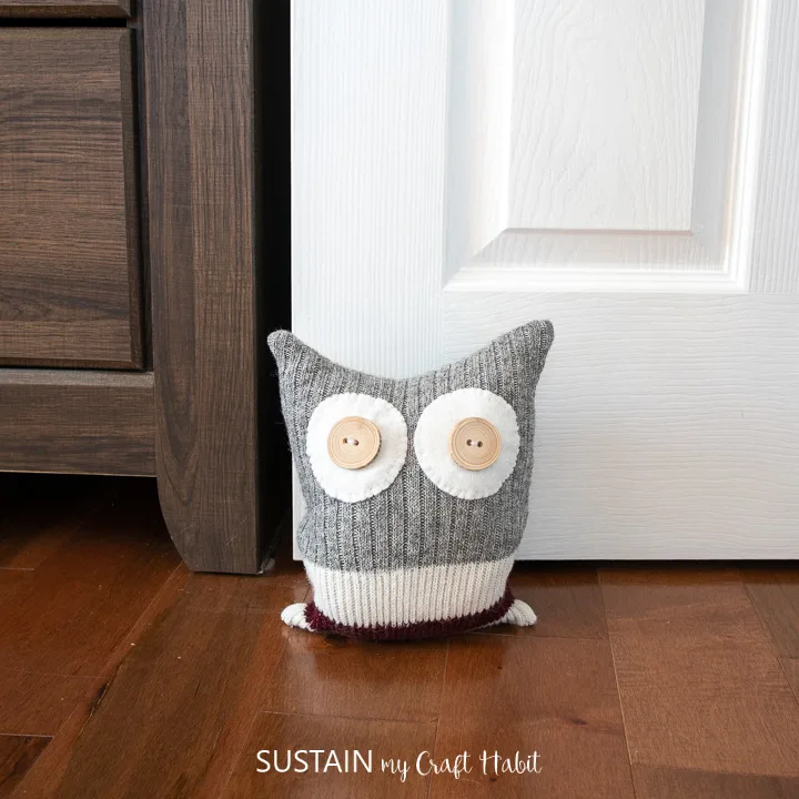 an upcycled owl doort stop holding open a bedroom door