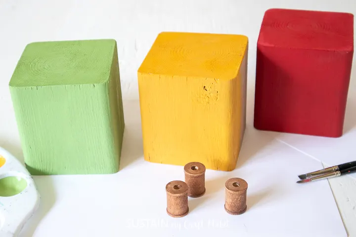 Painted wood blocks and wooden spools.