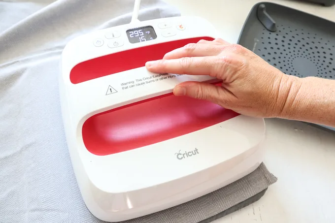 Pressing the EasyPress 2 machine over the lettering and tea towel.