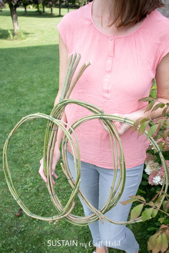 holding a pumpkin wreath form made from mulberry vines