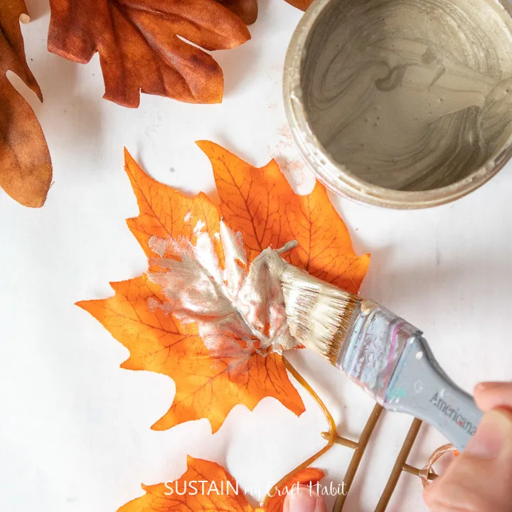 Painting a faux maple leaf with Champagne Metallic paint.