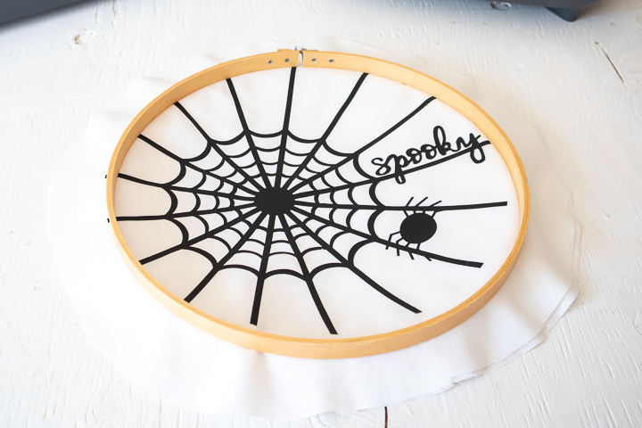 Inserting the spider web fabric into the embroidery hoop.
