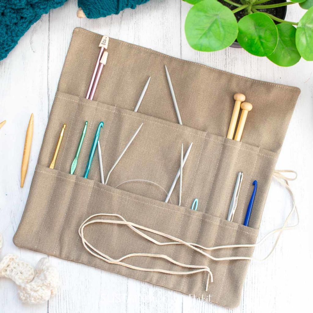 An easy to sew knitting needle organizer holding various sized needles and crochet hooks.