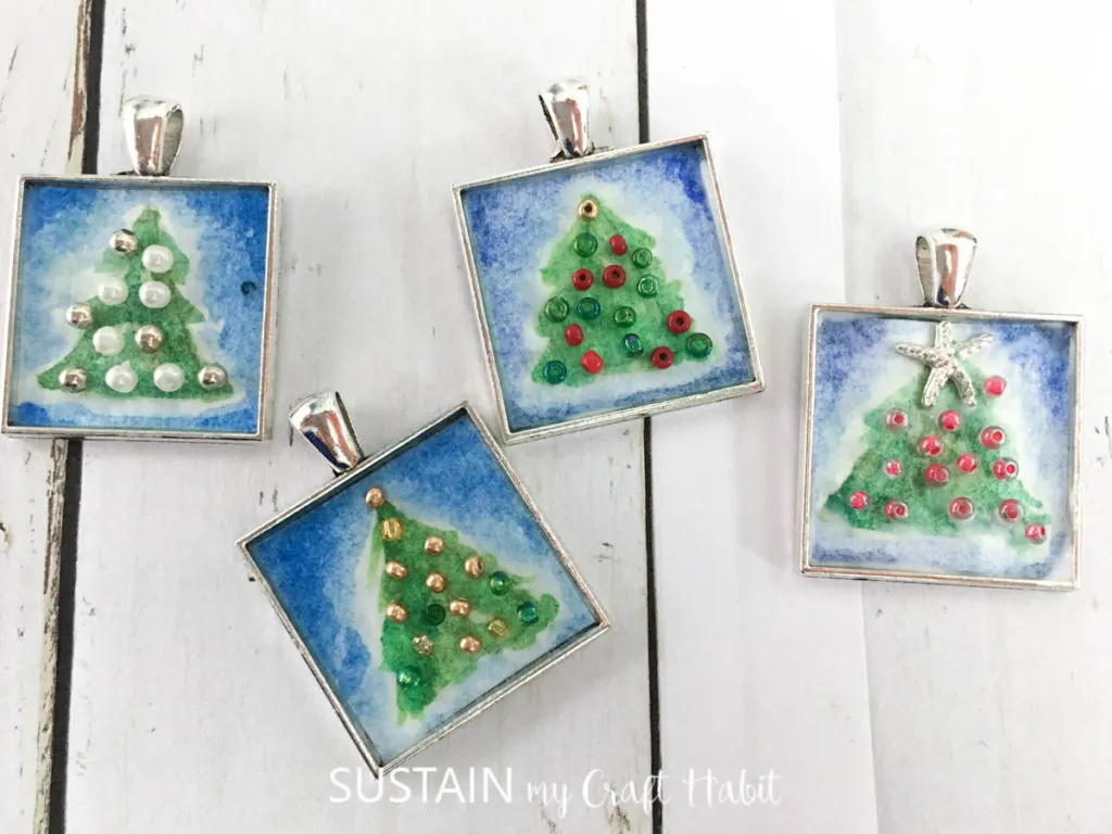 Decorated bezel charms with painted Christmas trees and beads.